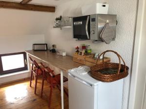 a kitchen with a counter with a microwave and a table at SaidenbachHaus in Großhartmannsdorf