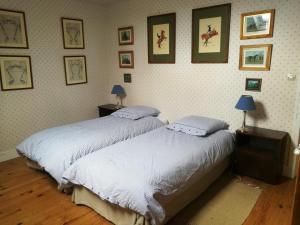 Duas camas num quarto com fotografias na parede em chez Zaza em Stigny