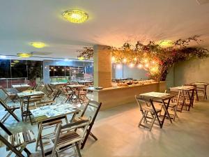a restaurant with tables and chairs and a counter at Porto de Galinhas PORTO EXCLUSIVE BY AFT in Porto De Galinhas