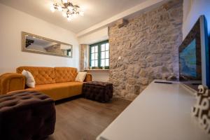 uma sala de estar com um sofá e uma parede de pedra em Didov dvor em Ražanac