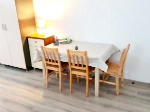 a dining room table with four chairs and a white table at Anna CENTRUM - pokoje przy Plaży in Giżycko