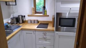 a kitchen with a counter with a microwave and a refrigerator at Sans, Souci. @ Mill House in Horncastle