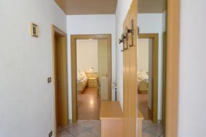 セルヴァ・ディ・ヴァル・ガルデーナにあるApartments Jasminの廊下(2つのドア付)、ベッドルーム(ベッド2台付)