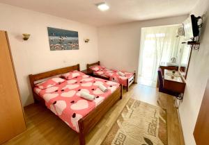 a bedroom with two beds and a window at Apartments Flamingo in Ulcinj