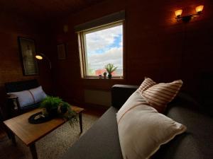a living room with a couch and a window at Haukland Camp Cabin in Leknes
