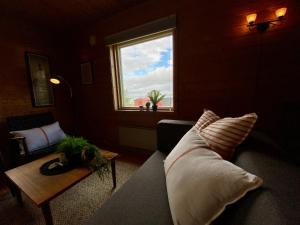 Una sala de estar con un sofá y una ventana. en Haukland Camp Cabin, en Leknes