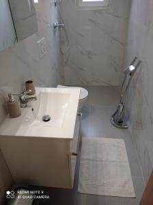 a white bathroom with a sink and a shower at Berat Apartment in Vodnjan