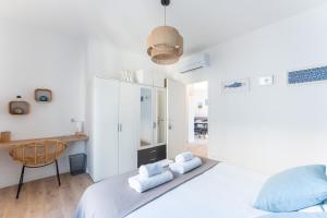 a white bedroom with a bed and a chair at ROCCA BIANCA - Sur la roche face à la mer et la bonne mère in Marseille