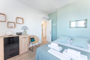 a bedroom with a blue bed with a desk and a chair at ROCCA BIANCA - Sur la roche face à la mer et la bonne mère in Marseille