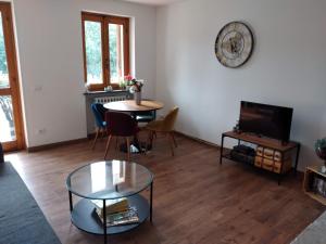 a living room with a table and a tv at Appartamento a due passi da Burcina in Favaro
