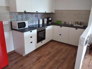 a kitchen with white cabinets and a microwave at Appartamento a due passi da Burcina in Favaro