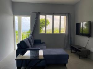 a living room with a couch and a tv at Hilltop Condos in Gros Islet