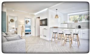 a living room with a kitchen and bar with stools at Le Vallaya Suites & Spa in Menton