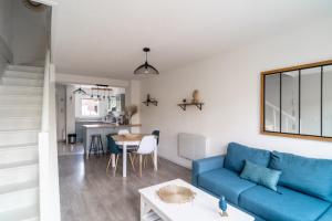 sala de estar con sofá azul y mesa en LES RENARDS - Charmante petite maison au port de la Teste, en La Teste-de-Buch