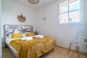 a bedroom with a bed with two towels on it at LES RENARDS - Charmante petite maison au port de la Teste in La Teste-de-Buch