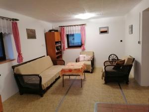 ein Wohnzimmer mit einem Sofa und einem Stuhl in der Unterkunft Na samotě u lesa in Libňatov