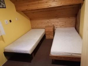 2 Betten in einem Zimmer mit Holzwänden in der Unterkunft Na samotě u lesa in Libňatov