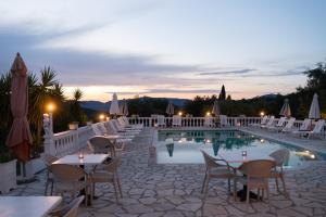 een resort met een zwembad en tafels en stoelen bij Villa Myrto in Pelekas