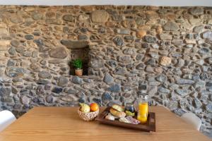 a wooden table with a tray of food and orange juice at Cellar House - Casa do Palheiro in Miranda do Corvo