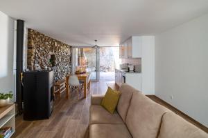 un soggiorno con divano e cucina di Cellar House - Casa do Palheiro a Miranda do Corvo