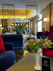 a lobby with a vase of flowers on a table at King Plaza in Tashkent +84 photos