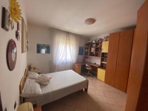Habitación pequeña con cama y escritorio. en Camere Rosy en Palazzo
