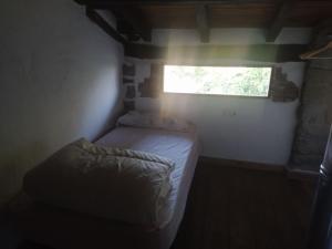 La caseta de El Llancís في L’ Esquirol: غرفة نوم صغيرة بها سرير ونافذة