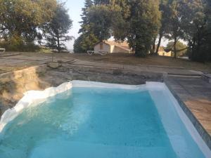 uma grande piscina de água azul num quintal em La caseta de El Llancís em L’ Esquirol