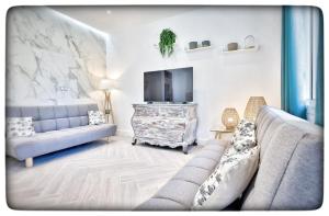 a living room with a couch and a tv at Le Vallaya Suites & Spa in Menton