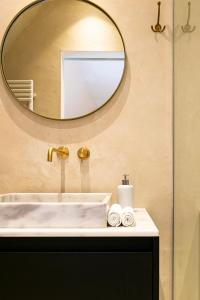 uma casa de banho com um lavatório e um espelho em Melindis B&B em Jabbeke