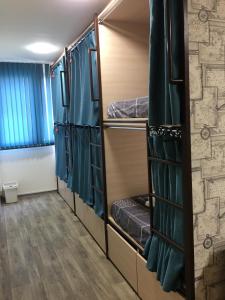 a room with bunk beds with blue curtains at Bonvenon capsule Hostel in Yerevan