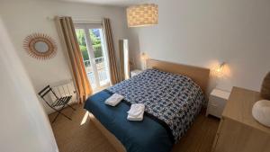 een slaapkamer met een bed met twee handdoeken erop bij Côté lac in Gérardmer