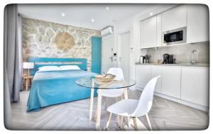 a bedroom with a blue bed and a table and chairs at Le Vallaya Suites & Spa in Menton