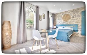 a bedroom with a bed and a table and chairs at Le Vallaya Suites & Spa in Menton