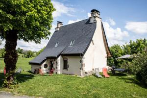 una pequeña iglesia blanca con techo negro en Maison typique des monts du Cantal, en Marmanhac