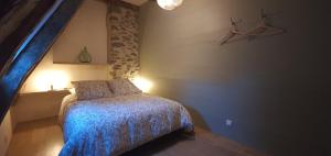 a bedroom with a bed with a blue comforter at Maison typique des monts du Cantal in Marmanhac
