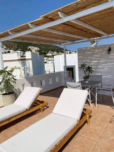two white lounge chairs and a table on a roof at Ammos 1 in Panteli