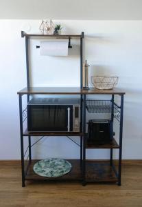 a black shelf with a microwave on it at Ferienwohnung "Casa El Aberle" Modern eingerichtet in schöner Lage mit Parkplatz in Stockach