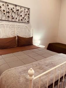 1 dormitorio con 1 cama grande con marco blanco en B&B Meliora Rooms, en Avola