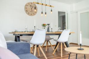 une salle à manger avec une table, des chaises et une horloge dans l'établissement Ferienwohnung Landparadies im Sauerland, à Bestwig