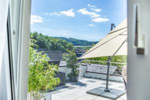 a view from the balcony of a house with an umbrella at Ferienwohnung Landparadies im Sauerland in Bestwig