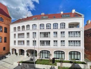 un gran edificio blanco con techo rojo en Kurkowa Apartments, en Szczecin