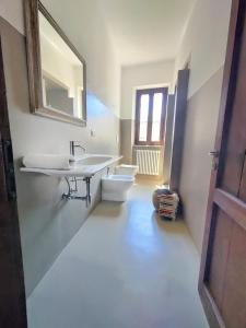 a bathroom with two sinks and a toilet and a mirror at Borgo Francia in Cremolino +35 photos