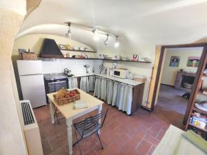 a kitchen with a table and a stove and a refrigerator at Borgo Francia in Cremolino