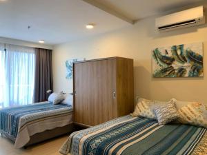 a bedroom with two beds and a large window at PUTEH Timurbay Beachfront Private Suite Kuantan in Kuantan