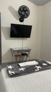 a bedroom with a bed with a television and a table at Aparta estudio amoblado 3 Medellin, San joaquin in Medellín