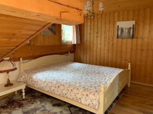 ein Schlafzimmer mit einem Bett in einem Holzzimmer in der Unterkunft Hüttenflair im Gut Sonnenwald in Schöllnach