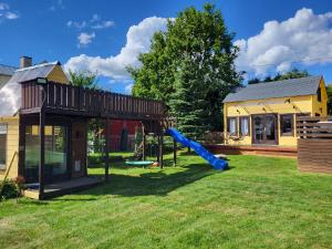 un parque infantil en un patio junto a una casa en Tiny house near Viljandi lake en Viljandi