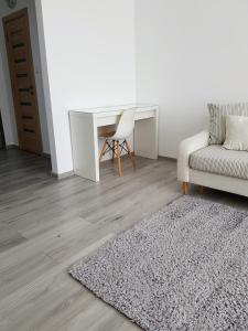 - un salon avec un canapé, une table et un tapis dans l'établissement Alexa Apartament, à Târgu-Mureş