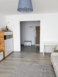 a white living room with a couch and a table at Alexa Apartament in Târgu-Mureş